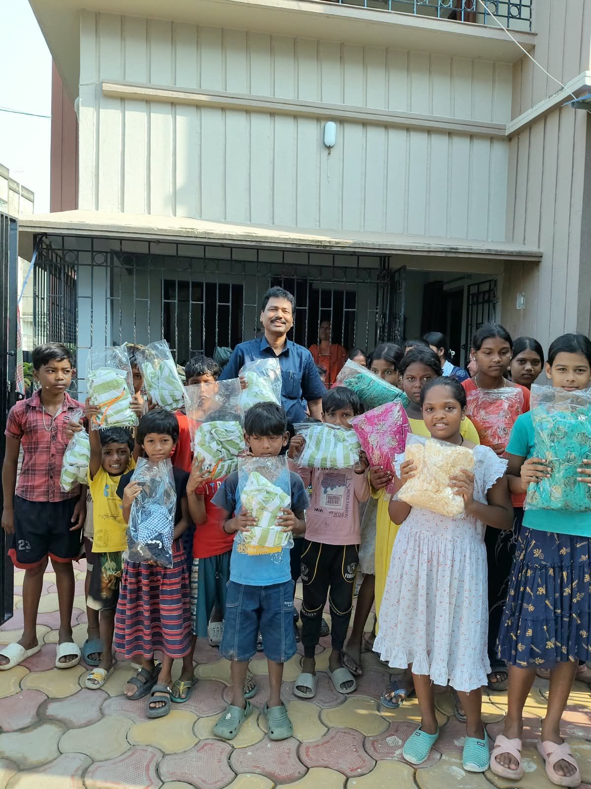 Children holding up relief packets outside a building