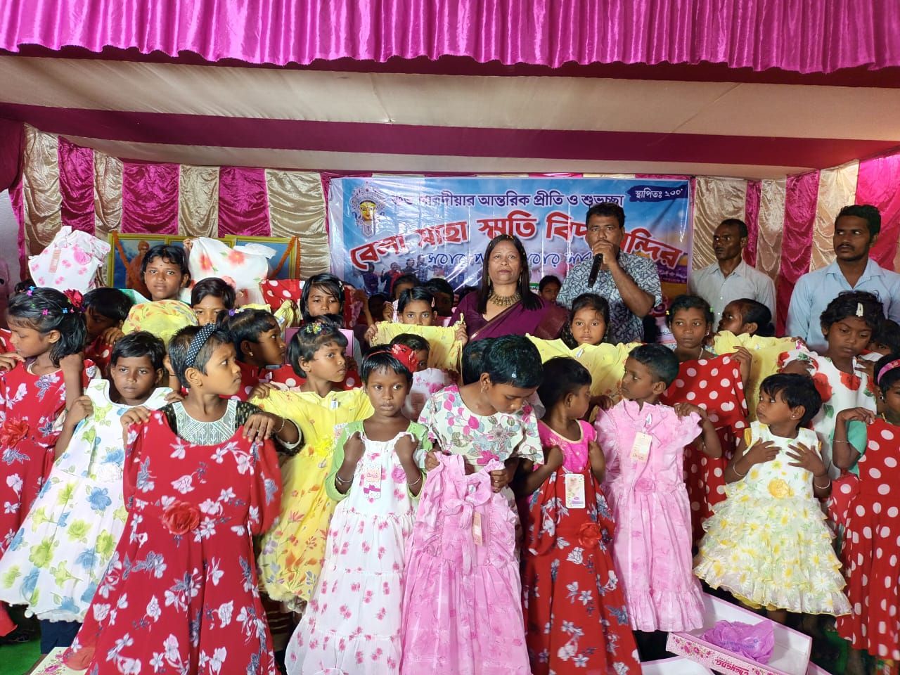 Young girls in colourful new frocks at a festive distribution