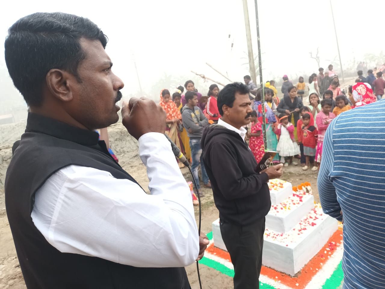 Community members saluting during a flag hoisting ceremony