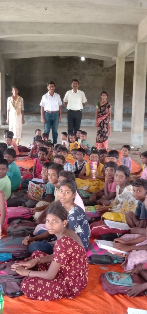 Students seated in a large hall with their new school bags